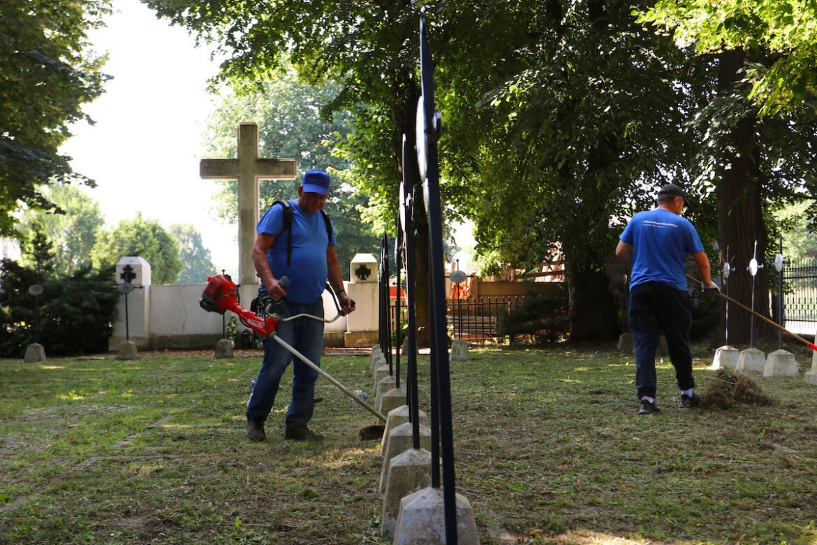 Pracownicy Infrastruktura Niepołomice sprzątają cmentarz wojenny w Niepołomicach